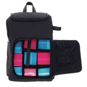 Black Spectrum TCG Backpack shown open, displaying the configurable interior compartments filled with colorful card deck boxes in blue and pink. The right side of the backpack flap has additional pockets for accessories or smaller items.
